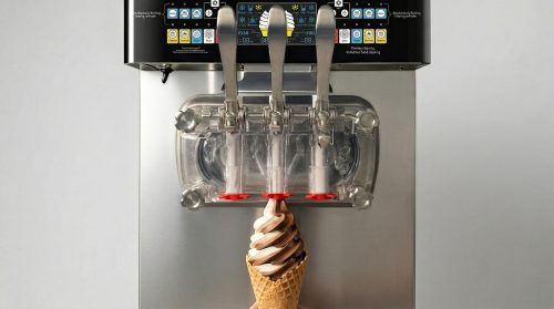 A commercial twin-cylinder soft serve ice cream machine, capable of single-flavor and twin-twist outputs, with a two-color cone directly underneath.