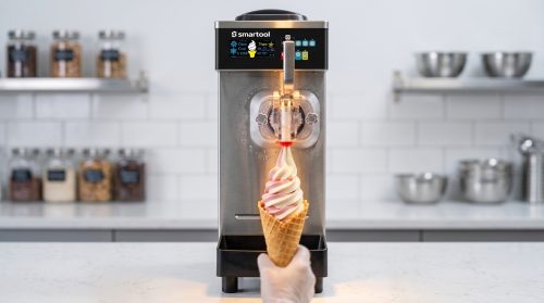 Blogs 5 Close-up of an ETL-certified Smartool commercial soft serve machine smoothly dispensing dual-flavor ice cream into a waffle cone, highlighting its food-grade materials and reliable performance for busy food service businesses.